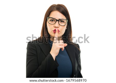 Portrait of young business girl making silence gesture isolated on white background