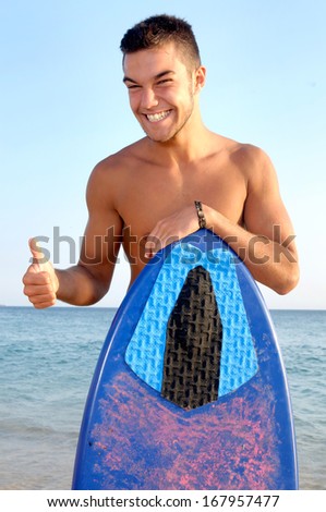 teenage boy with skimboard at the beach