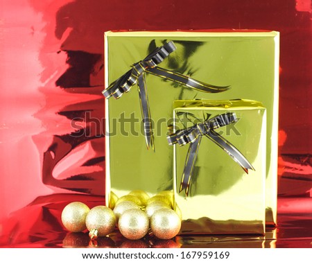 GOLD Christmas gift box with its lid propped at an angle in front to display the beautiful shiny metallic gold ribbon with falling winter snowflakes and copyspace for your greeting or wishes 
