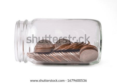 Coins inside of money jar on white background. Isolated with clipping path photo and saving for investment concept.