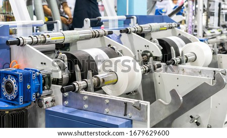 raw material plastic roll set on support unit shaft for supply or feed to modern automatic blow or injection for continuous manufacturing process sack bag making machine Royalty-Free Stock Photo #1679629600
