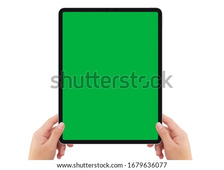 Isolated human left hand holding vertical black tablet media device with white empty screen mockup on white background