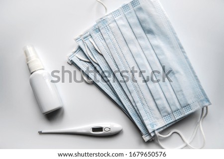 Protective medical masks, antiseptic and thermometer.