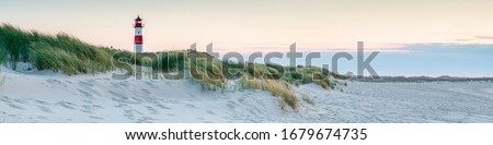 Panoramic view of a lighthouse standing at the coast of Sylt, North Sea, Germany Royalty-Free Stock Photo #1679674735