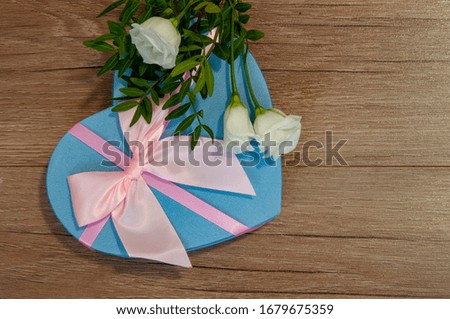 Heart box with beautiful flowers on wooden background