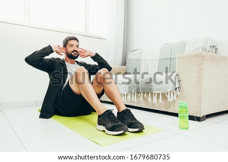 Man working out at home doing sit ups Royalty-Free Stock Photo #1679680735