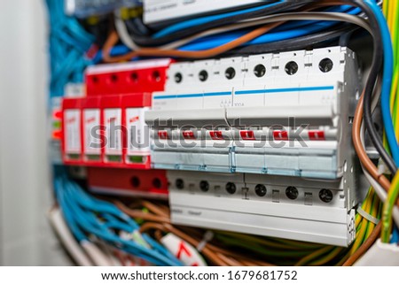 Three-phase fuse in the ON position and surge arrester used to protect the electrical system in the building during electrical discharges, storm protection. Royalty-Free Stock Photo #1679681752
