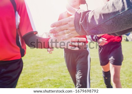 High Five line after a childs soccer game toned image, focus on adult hand Royalty-Free Stock Photo #1679698792