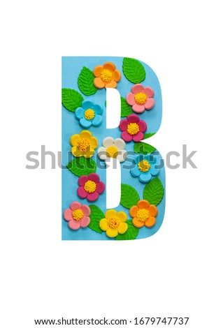The letters  B of the English alphabet is cut out of flowers on a blue  background.Floral pattern, texture for stores,sales,websites,postcards and holiday greetings.