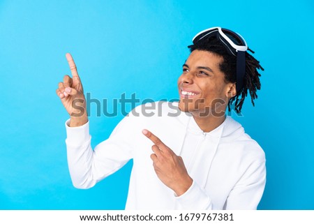 Young African American man with snowboarding glasses pointing with the index finger a great idea