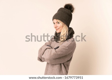 Young woman with winter hat over isolated background looking to the side