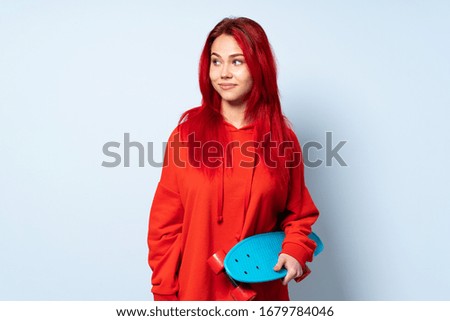 Teenager skater girl isolated on white background making doubts gesture looking side