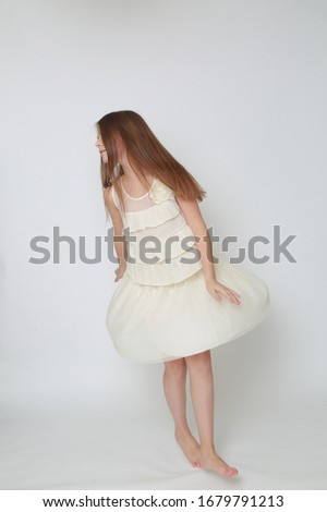 Studio image of happy emotional caucasian little girl moving and dancing