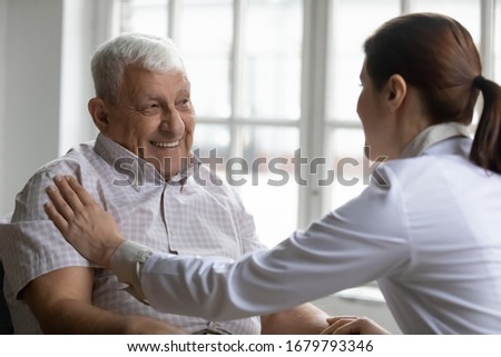 Old man and careful female nurse communication indoors, caregiver medical social worker touch hand of provide help to patient, good carer gives moral support, express empathy and kind attitude concept Royalty-Free Stock Photo #1679793346
