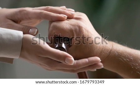 Close up of carer strokes hands of senior man hold cane showing warm attitude at sincere talk empathize to old patient, life troubles relieve loneliness goes through diseases with caring nurse concept Royalty-Free Stock Photo #1679793349