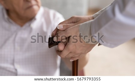 Caring female nurse hands holding old man patient arms touch walking stick close up image. Provide help to older generation person, psychological physical support, physiotherapy, nursing home concept Royalty-Free Stock Photo #1679793355