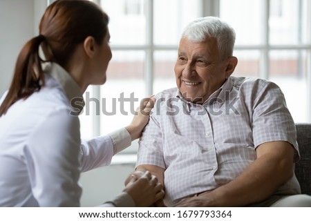 Caring nurse talks to old patient holds his hand sit in living room at homecare visit provide psychological support listen complains showing empathy encouraging. Geriatrics medicine caregiving concept Royalty-Free Stock Photo #1679793364