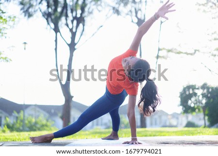 Portrait of young woman practicing yoga meditation during sunrise in the park. Calmness and relax, female happiness. Health lifestyle concept.
