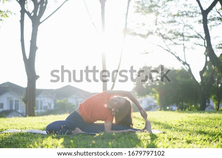 Portrait of young woman practicing yoga exercise during morning sunrise in the park. Calmness and relax, female happiness. Health lifestyle concept.