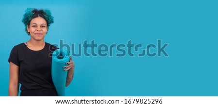young woman or girl with gymnastic mat isolated on afro american color background
