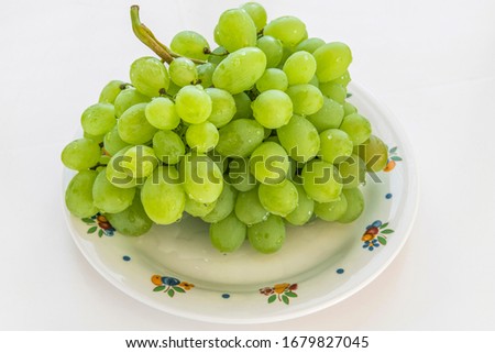 Green big bunch of grapes laying on the plate