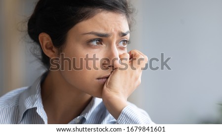 Close up thoughtful depressed unhappy Indian woman thinking about psychological problems, looking away alone, sad upset young female worried about break up with boyfriend, bas relationship Royalty-Free Stock Photo #1679841601