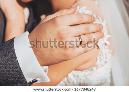 hands of the bride and groom with wedding rings 