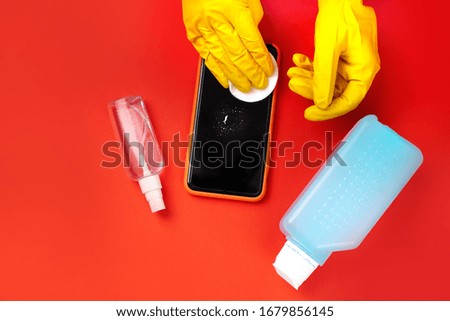 Smartphone cleaning with special anti bacterial spray. Antiseptic treatment during coronavirus quarantine. Top view. Royalty-Free Stock Photo #1679856145