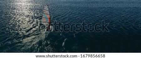 Aerial drone ultra wide photo of wind surfer cruising in high speed in tropical exotic bay