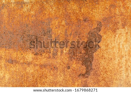 Old rusty metal wall with traces of paint