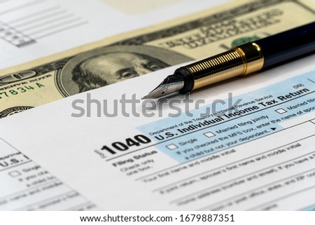 Tax form with pen and dollar banknote. document are mock-up