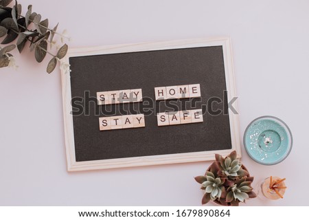 Words stay home, stay safe made of wooden blocks, concept of self quarantine at home as preventative measure against virus outbreak. Flat lay with inspiration quote, staying at home during pandemic Royalty-Free Stock Photo #1679890864