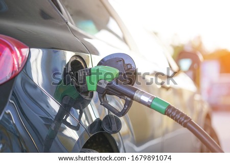 Refueling a car at a gas station. Fuel nozzle to refill fuel in car at gas station, copy space. Close-up of gas pump fill at a gas station car.