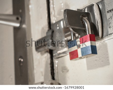 A bolted door secured by a padlock with the national flag of Dominican Republic on it.(series)