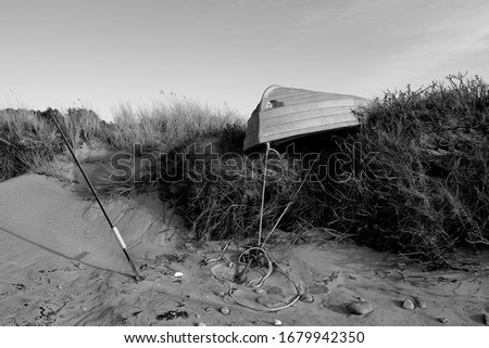 Laesoe / Denmark: Small fishing boat ashore on the edge of the beach to the dunes
