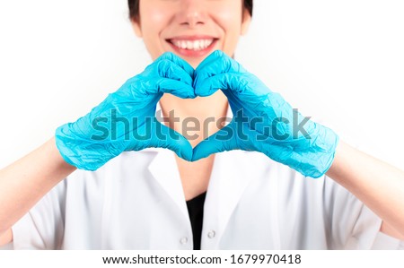 young woman doctor doing the heart sign. White background