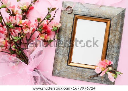 Original wedding invitation design. photo frame, bouquet of pink flowers and a wedding ring