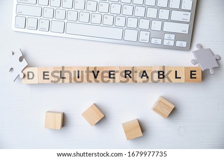 Modern business buzzword - deliverable. Top view on keyboard and puzzle with wooden blocks. Close up. Top view. Royalty-Free Stock Photo #1679977735