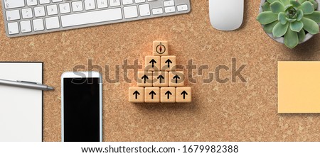 stacked cubes on cork background with a compass symbol on top symbolizing to organize a team to a common goal