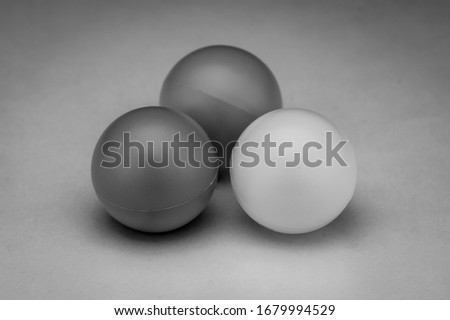 Group of three ping pong balls in black and white 
