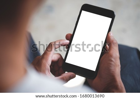 Cropped shot view of man hands holding smart phone with blank copy space screen for your text message or information content, female reading text message on cell telephone during in urban setting. Royalty-Free Stock Photo #1680013690