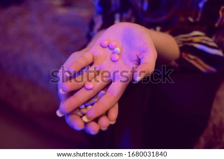 Girl holds pills in her hands. Female hands hold many pills. Hands hold pink, white pills, medicine. Coronavirus tablets.