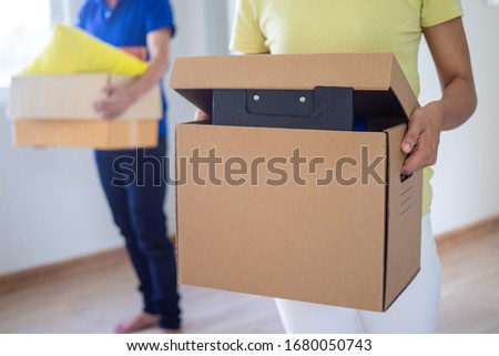 Couples helped each other move the brown box into the new house. concept of changing to a new residence / house