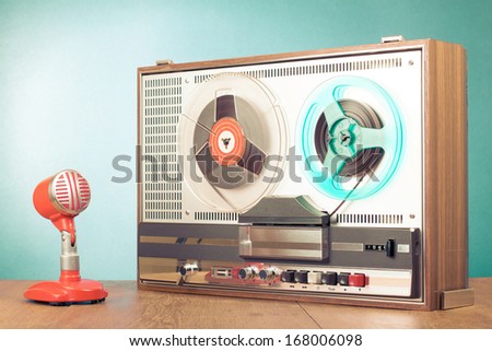 Reel to reel retro tape recorder and microphone on table