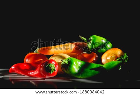 Vegetables in spotlight in front of dark background