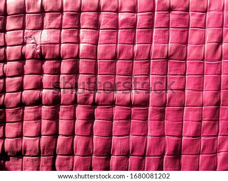Dark red color blanket with checkered texture and drying in the sun