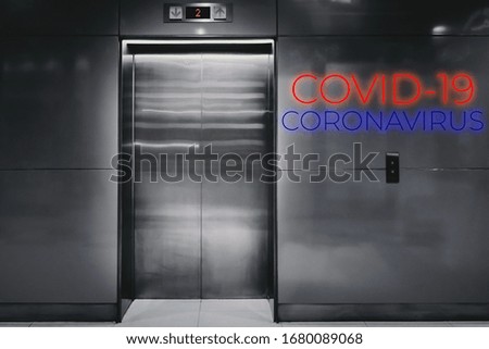 Warning text COVID-19 and CORONAVIRUS on front of elevator textured background.