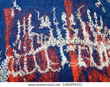 Decorative wallpaper design.Abstract grunge blue white and red background fabric flag quilted with thread.The texture of the darning threads.