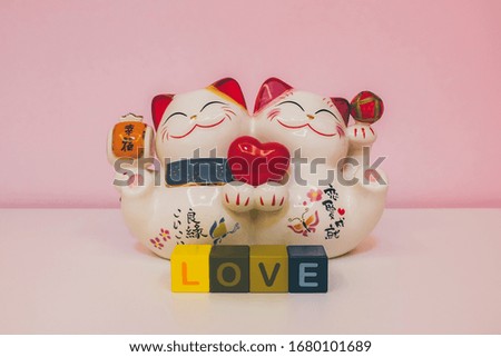 Lucky cat representing love, the asian characters mean:(from the left to the right) happiness,  happy match, love achievement.