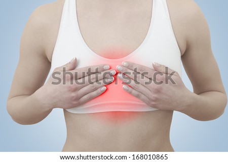 Acute pain in a woman chest. Female holding hand to spot of chest-ache. Concept photo with Color Enhanced blue skin with read spot indicating location of the pain. 